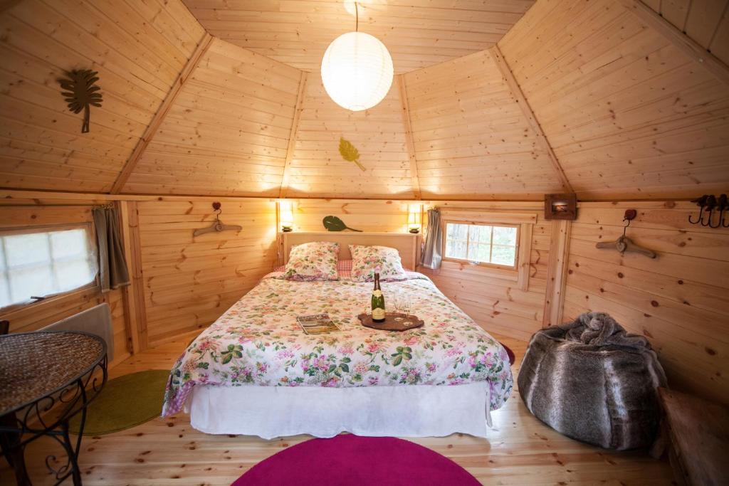 una camera con un letto in una cabina di legno di La Roche aux Fées a Lapte