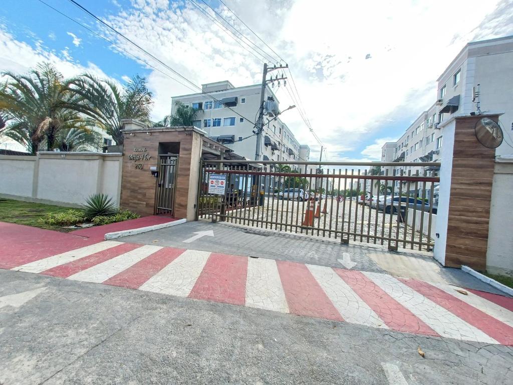 a gate with a red and white stripes on a street at Apê UNIFA-EsSLog Condomínio com estacionamento in Rio de Janeiro