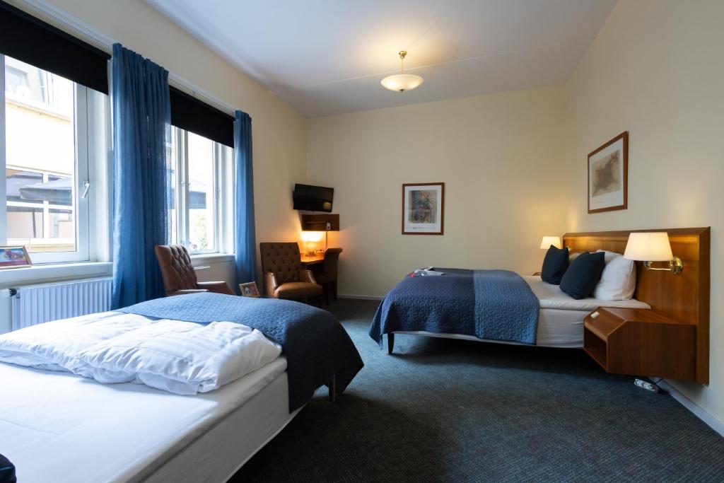 Una habitación de hotel con dos camas y una ventana. en Milling Hotel Gestus, en Aalborg