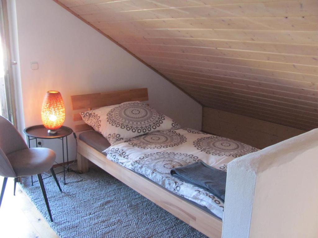 een slaapkamer met een bed en een lamp op een vloer bij #4 Dachstudiozimmer mit 2 Betten und Balkon mit WG Bad Airport nah freies W-Lan in Trunkelsberg