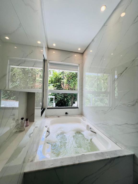 a large bath tub in a bathroom with a window at Casa com banheira in Governador Celso Ramos