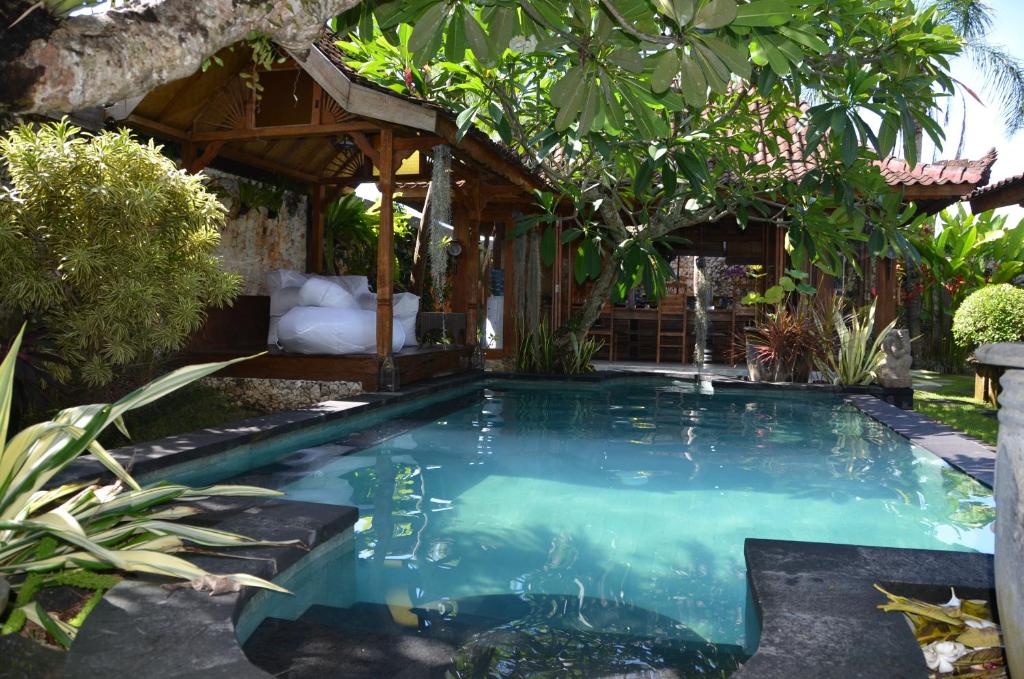 a swimming pool in the middle of a garden at Villa Eva in Canggu