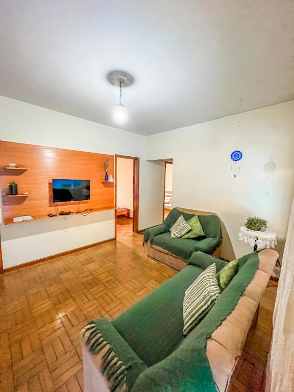 a living room with a couch and a tv at Ótima casa no centro de Carrancas in Carrancas