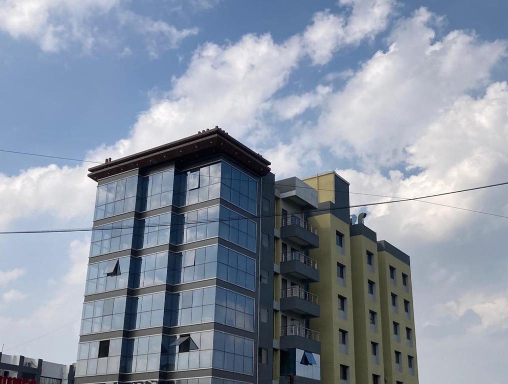 a tall glass building with a sky in the background at The Grand Sarovar Inn And Suites in Chakan