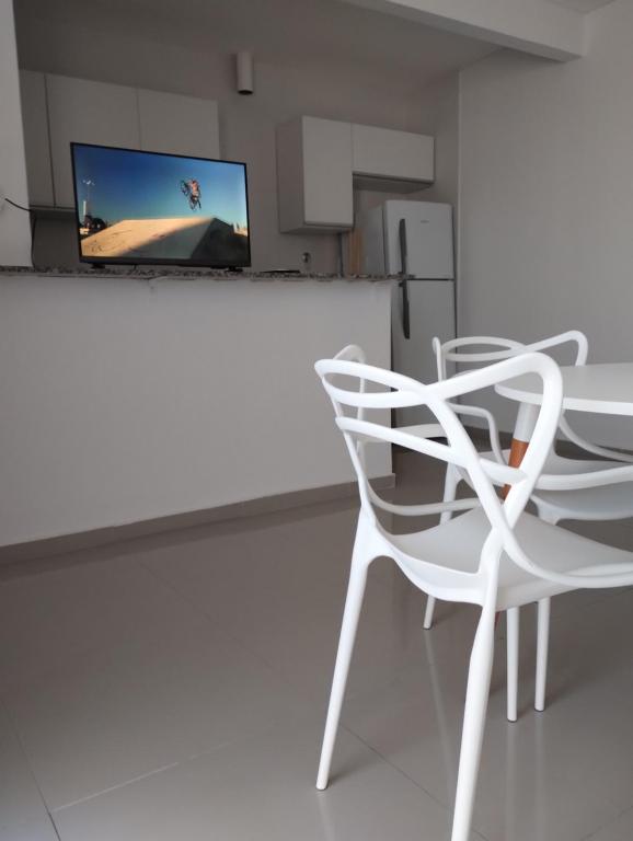 une chaise blanche et une télévision dans la chambre dans l'établissement AMPLIO DEPARTAMENTO CENTRICO TODO INCLUIDO 4b, à San Nicolás de los Arroyos