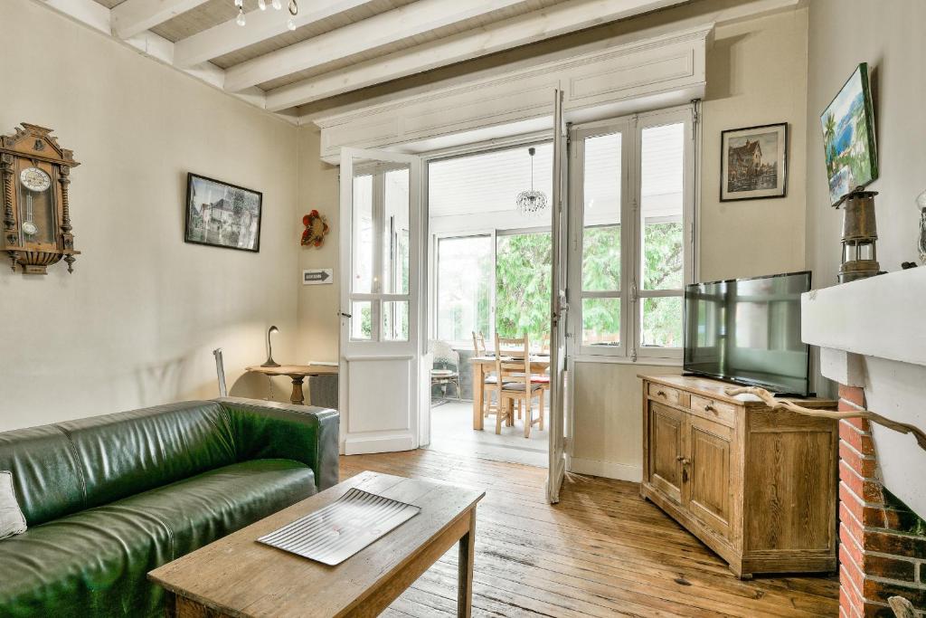 un salon avec un canapé vert et une table dans l'établissement Escapade à 150m de la plage du Betey, à Andernos-les-Bains