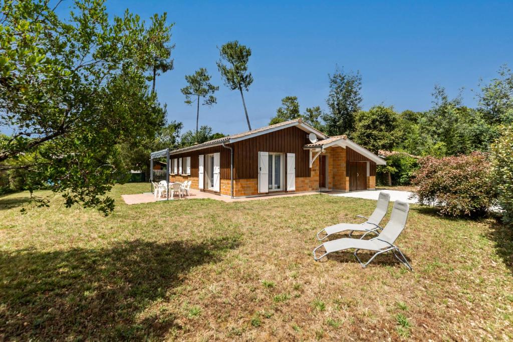 - deux chaises assises dans l'herbe devant une cabine dans l'établissement Vacances apaisantes au coeur du Bassin d Arcachon, à Lanton