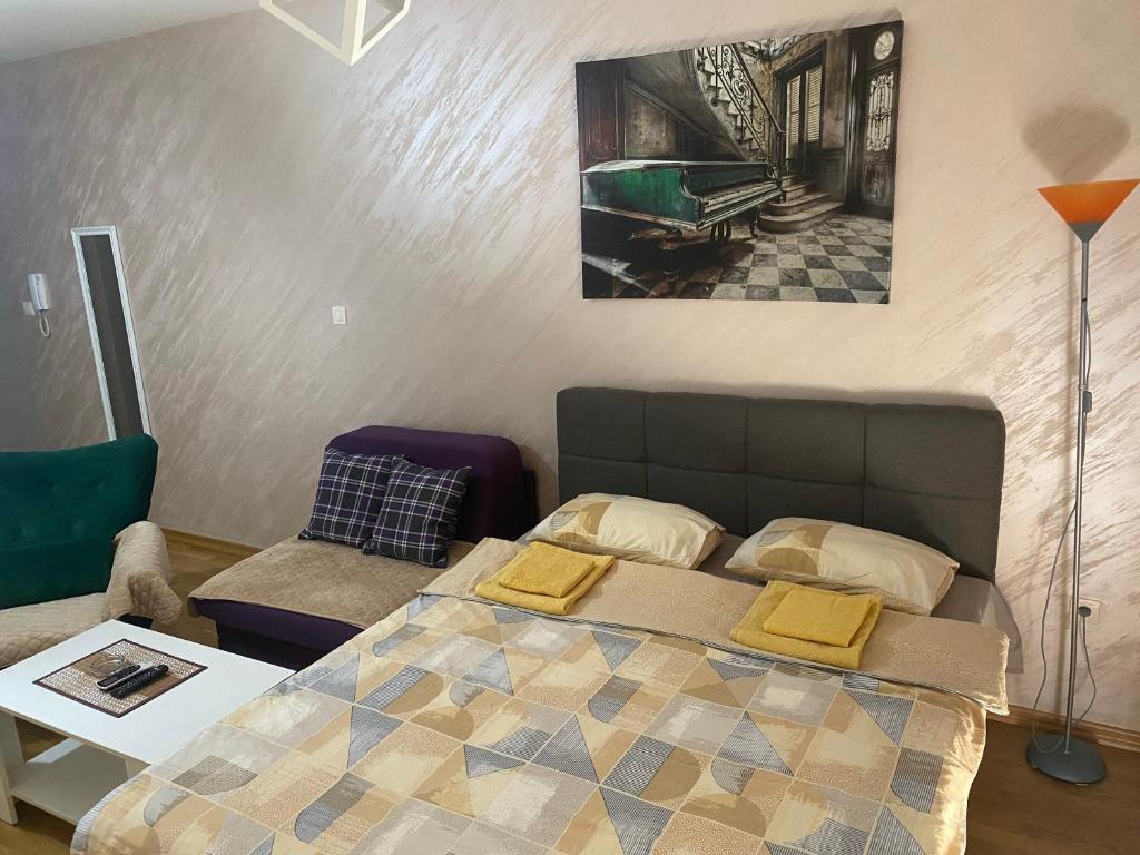 ein Schlafzimmer mit einem Bett, einem Sofa und einem Tisch in der Unterkunft Impressive Apartment in Nikšić