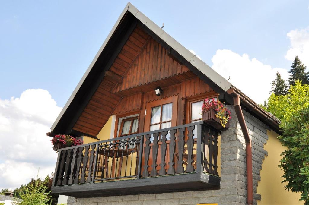 ein Haus mit einem Balkon mit Blumen darauf in der Unterkunft Ferienhäuschen Grenzland in Bad Elster