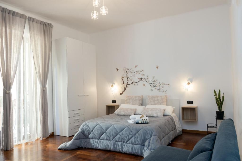 - une chambre blanche avec un lit et un canapé dans l'établissement ApuliaLux Prana Home - Bari City Center, à Bari