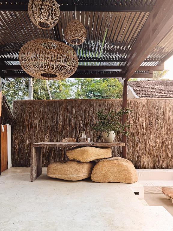 a room with a table and a bench and some plants at AMMA Boutique Hotel in Ahangama
