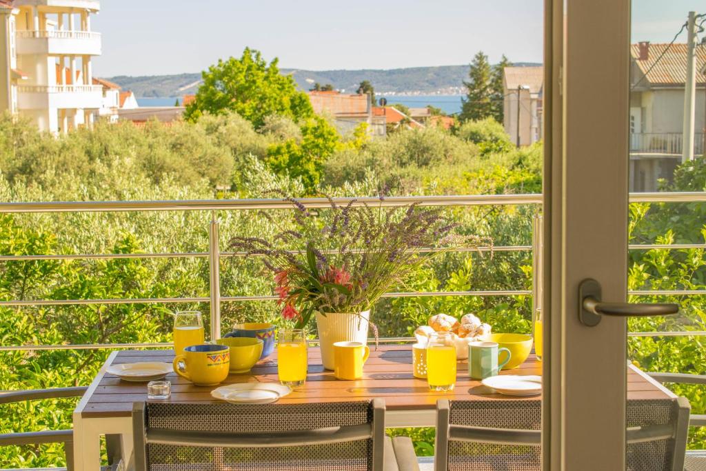 a dining table with a view of the ocean from a balcony at Apartments Villa Ornamenta - 5min to beach - free parking in Kaštela