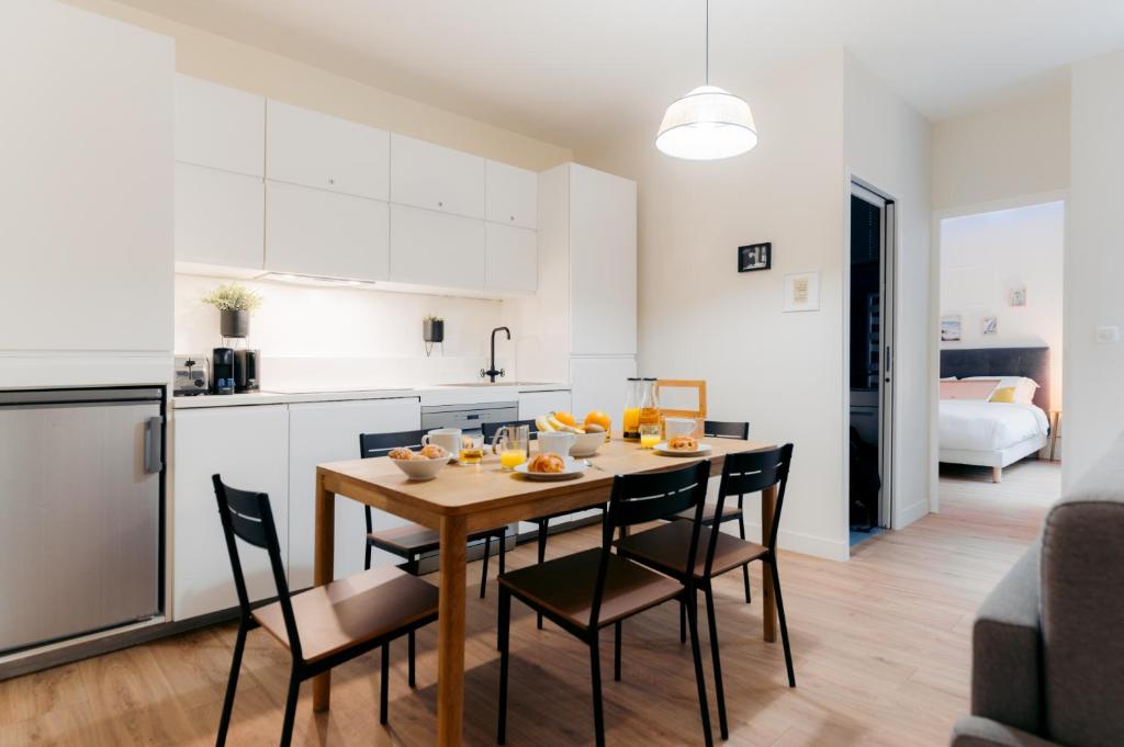 une cuisine et une salle à manger avec une table et des chaises dans l'établissement Beauvoir Germain, à Paris