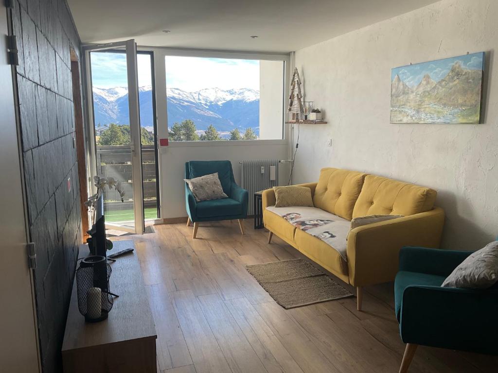 a living room with a yellow couch and two chairs at Appartement très lumineux in Égat