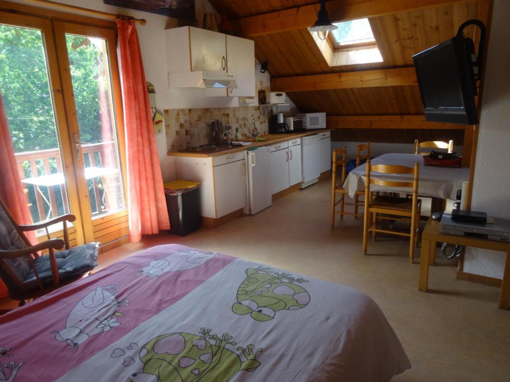 Habitación con cama y cocina con mesa en Appartement Saint-Chaffrey , 2 pièces, 5 personnes - FR-1-762-31, en Saint-Chaffrey