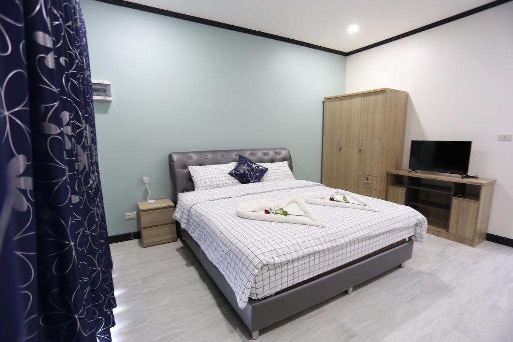 a bedroom with a bed and a tv in it at MB House in Ban Nai Rai