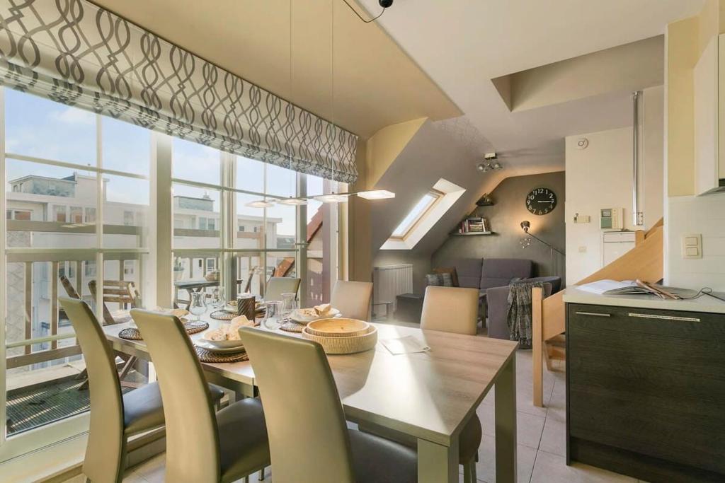 a kitchen and dining room with a table and chairs at Modern duplex apartment near the beach in Middelkerke