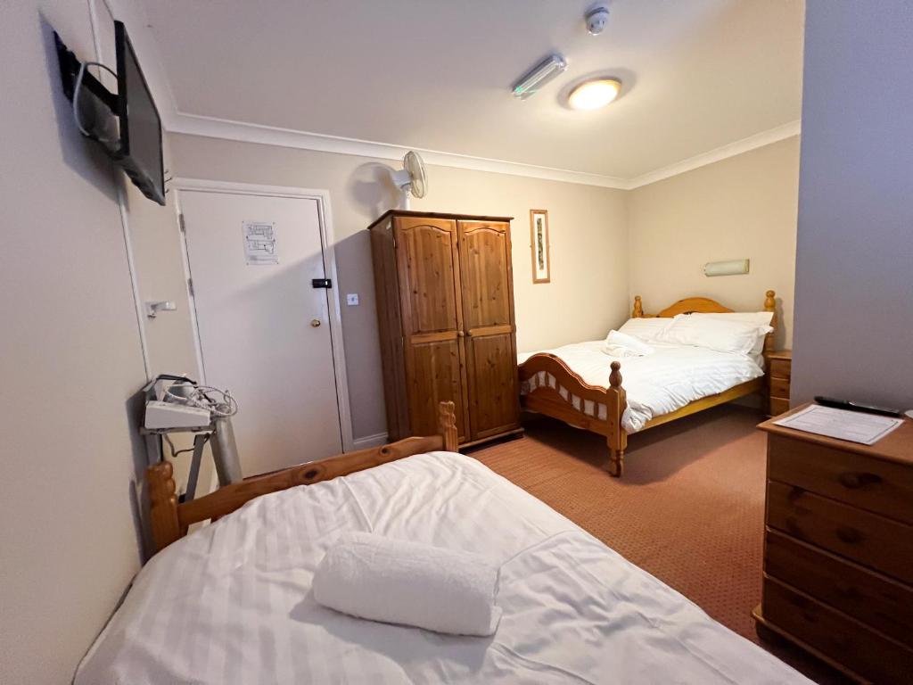 a bedroom with two beds and a dresser at The Exchange Hotel in Brigg
