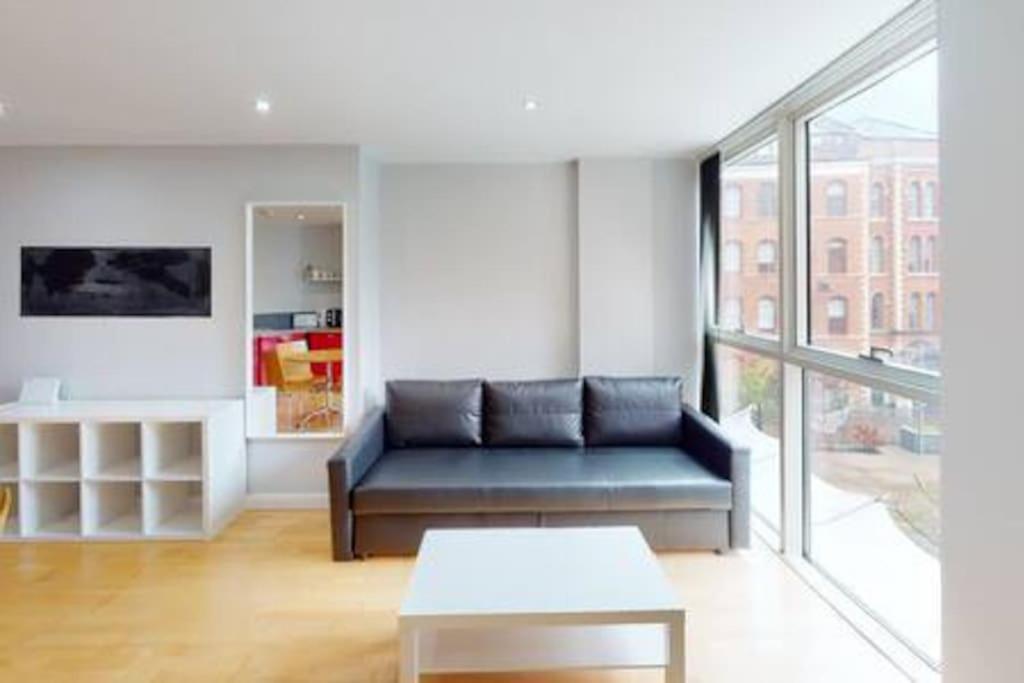 a living room with a blue couch and a table at 2 Bed Flat Centre of Lace Market in Nottingham