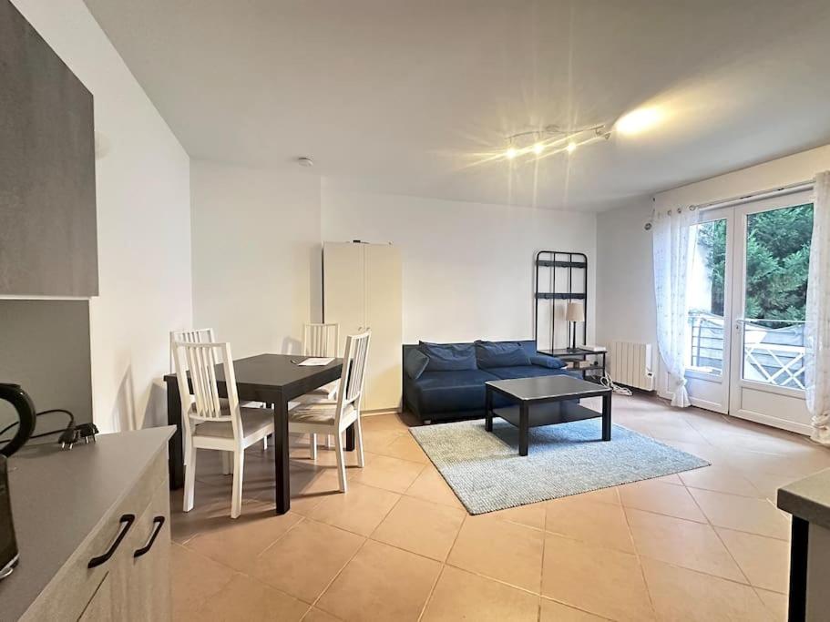 a living room with a blue couch and a table at Appartement F3, 2 chambres in Ivry-sur-Seine