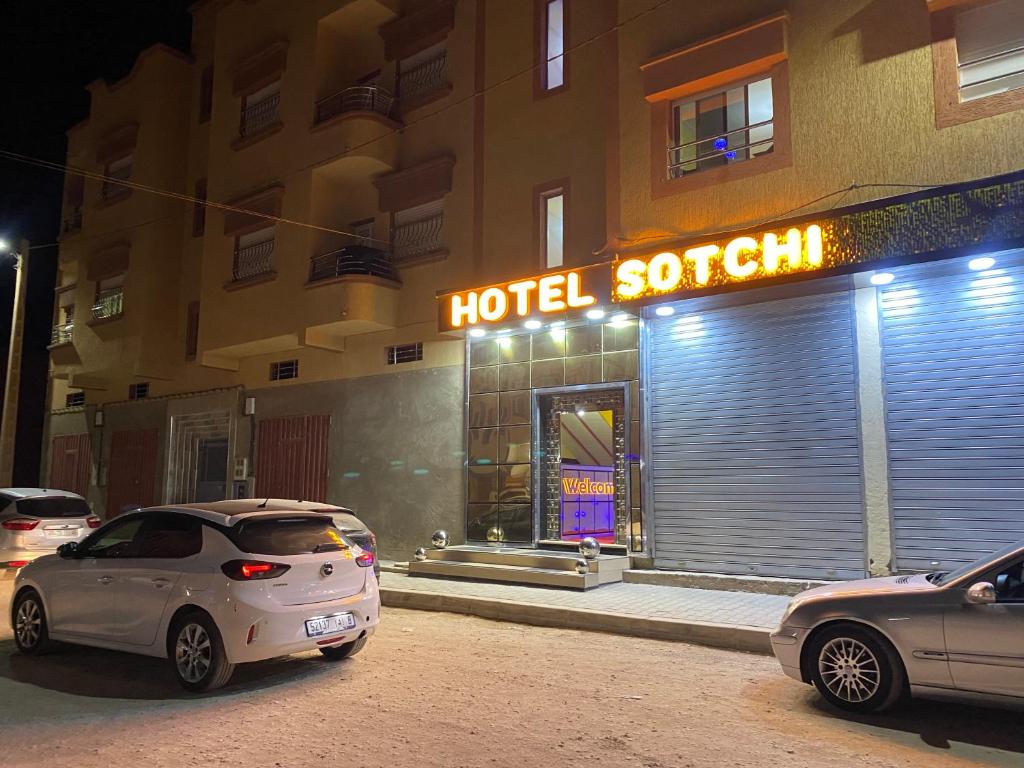 two cars parked in front of a hotel room at Hotel Sotchi 