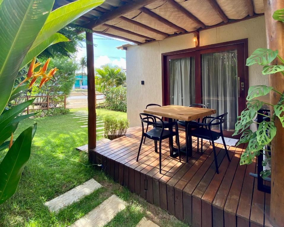 una terraza de madera con mesa y sillas. en Nari Guest Room en Fernando de Noronha
