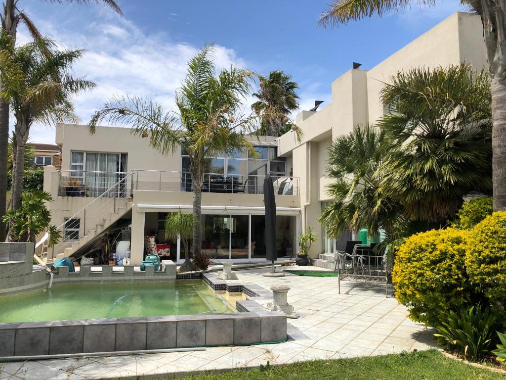 una casa con piscina y palmeras en Self Catering Guest House, en Ciudad del Cabo