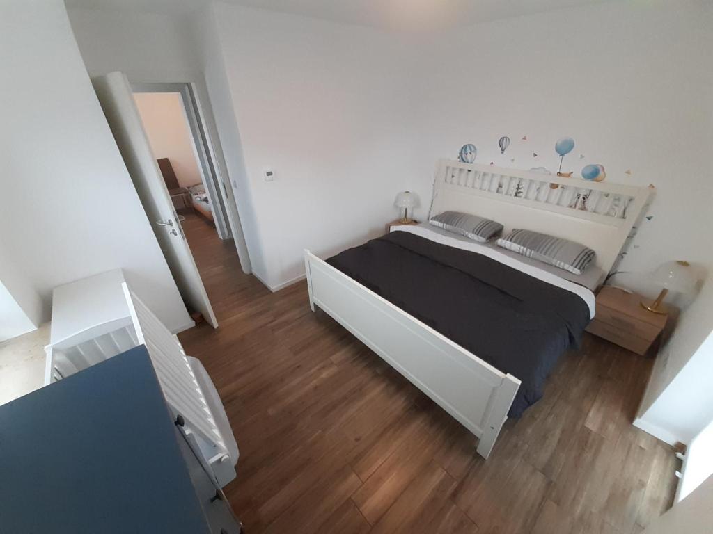 een slaapkamer met een groot bed en een houten vloer bij Haus Talheim Tuttlinger Str 8 