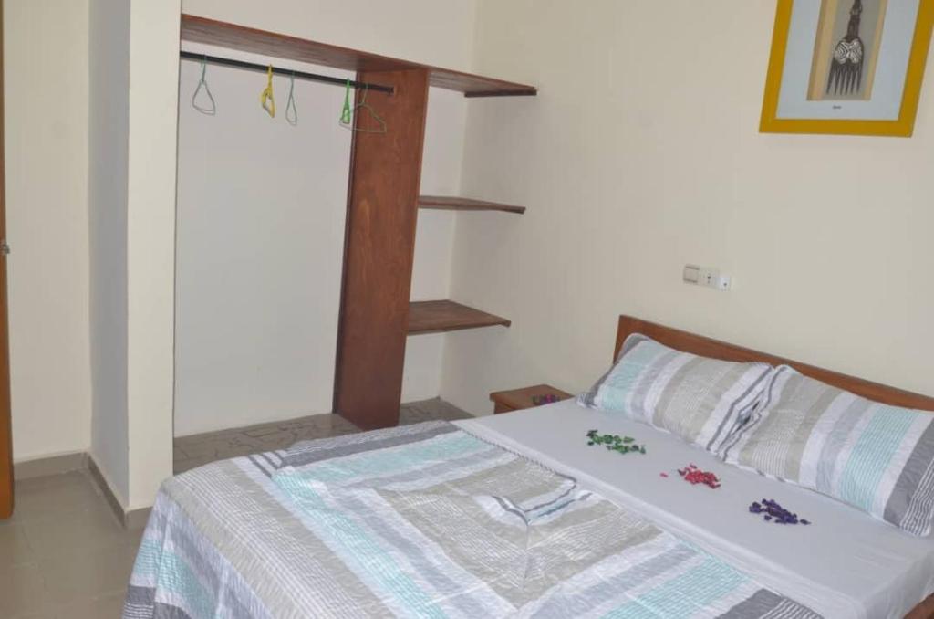 sypialnia z łóżkiem z drewnianą ramą w obiekcie GMJ Résidence w mieście Duala