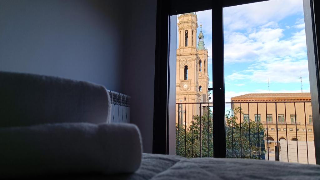 a view of a church tower from a window at LC Plaza del Pilar in Zaragoza