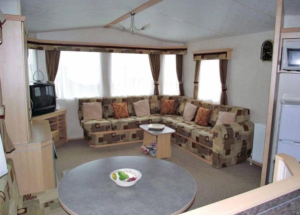 a living room with a couch and a table at Rowanbank Caravan Park in Beckfoot