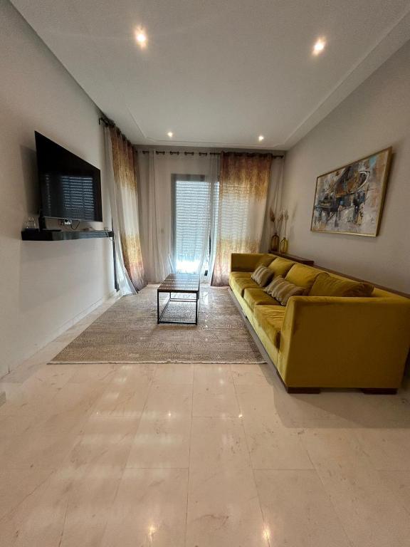 拉馬薩的住宿－luxueux duplex avec Rooftop a la Marsa，客厅配有黄色的沙发和桌子