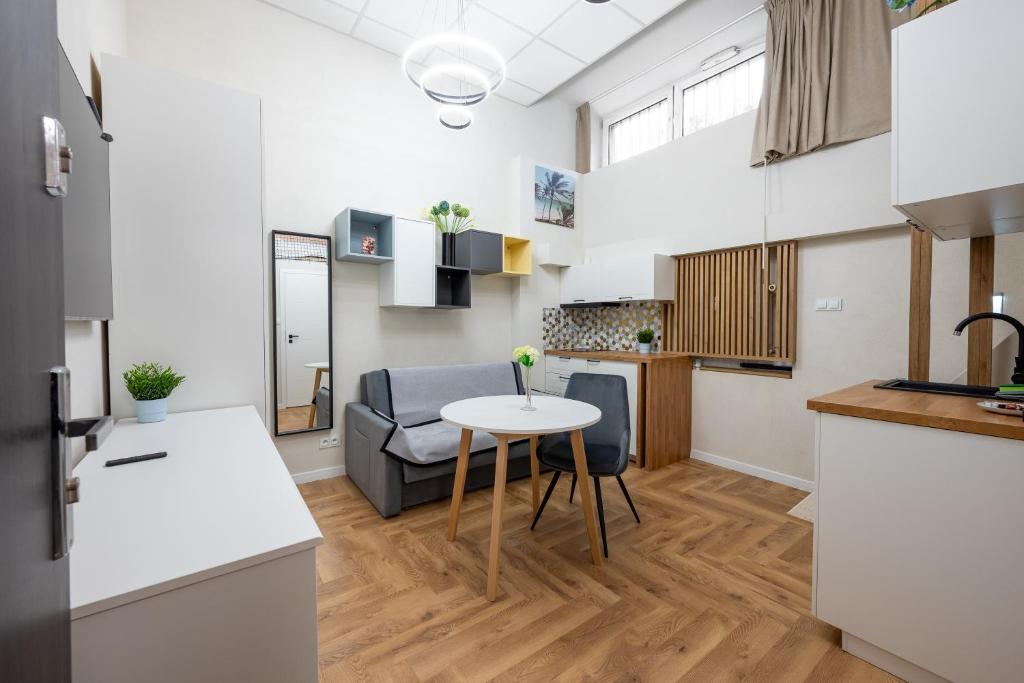 a kitchen and living room with a table in a room at Krasiński Garden Apartments in Warsaw