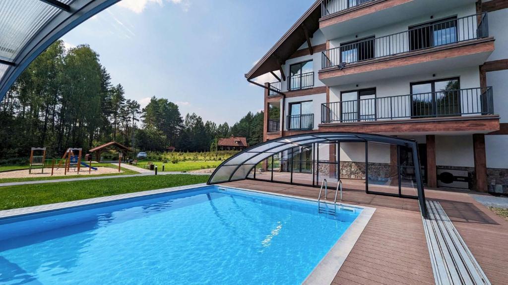 a large swimming pool in front of a building at Apartamenty Sun & Snow Zapach Lasu - Naturalne SPA in Karwica