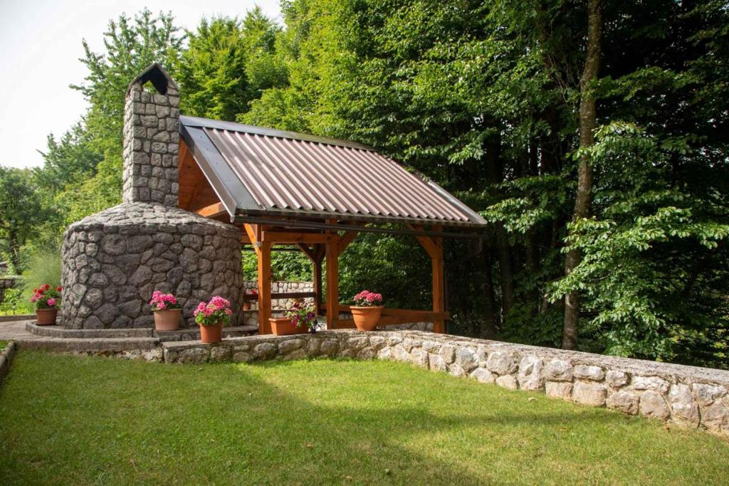 a gazebo in a yard with a stone wall at Holiday home in Lokve, Croatia 47707 in Lokve