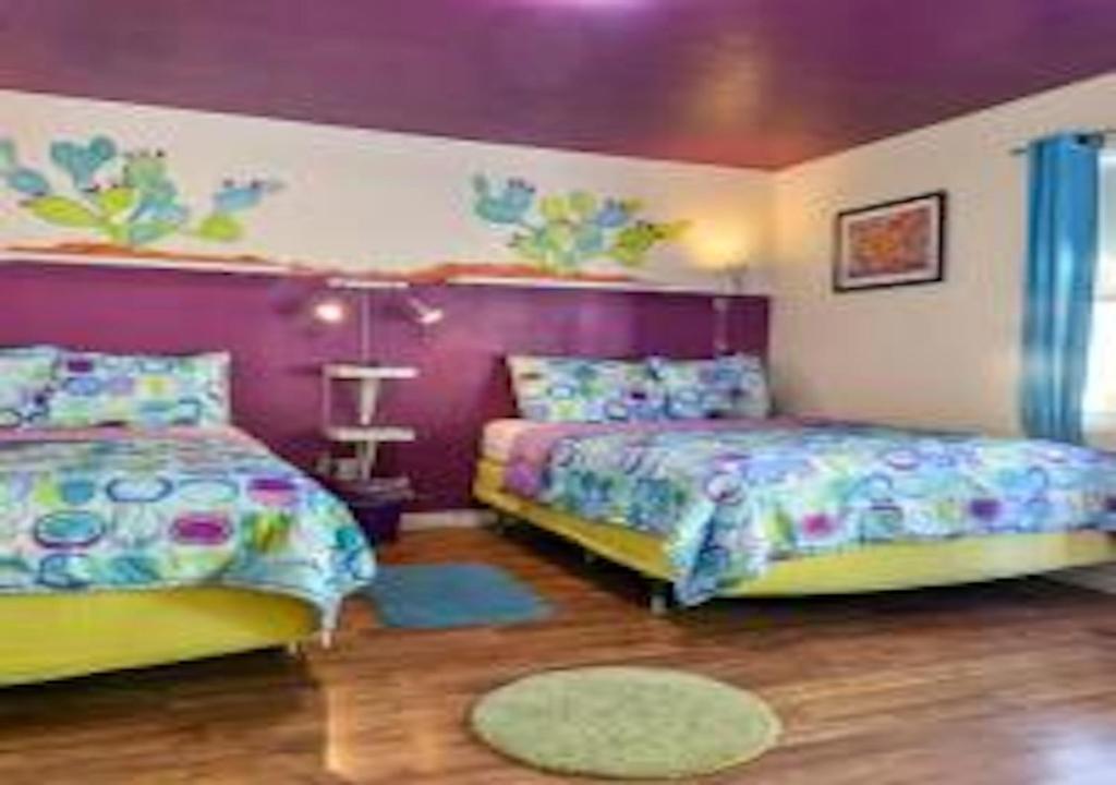 1 dormitorio con 2 camas y pared púrpura en Desert Dreams Studio, en Moab