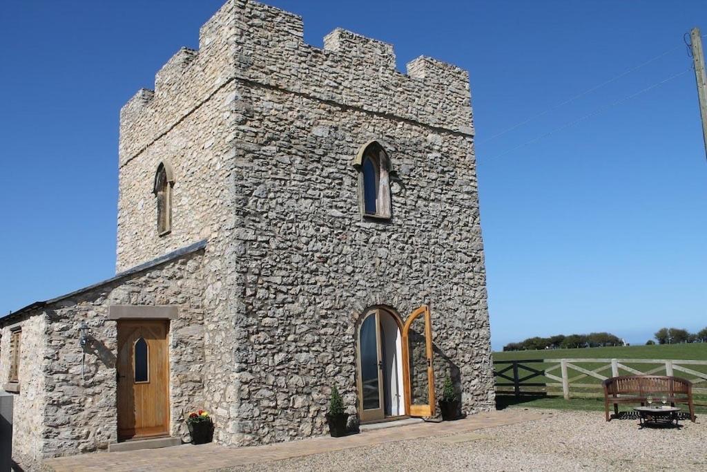 a stone building with a bench in front of it at Kinley Tower 