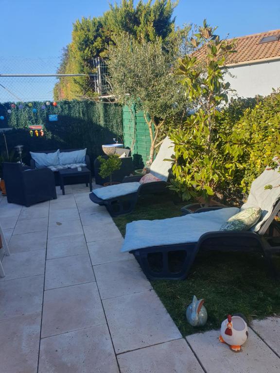 un jardin avec des coussins bleus sur la pelouse dans l'établissement La petite mézoise, à Mèze