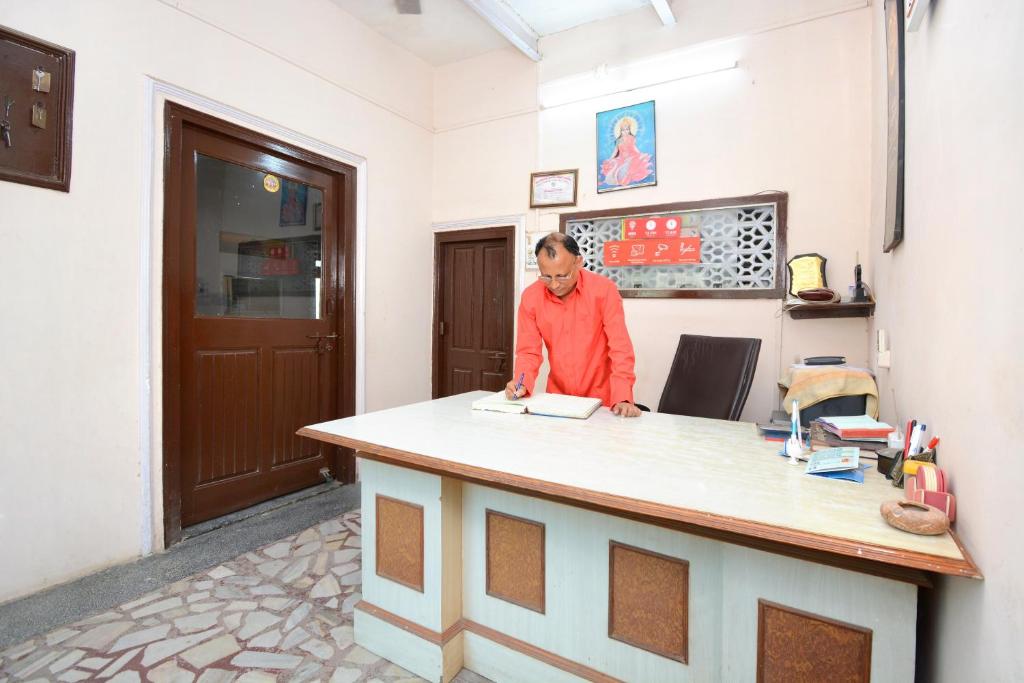a man is standing at a counter at OYO Flagship Hotel Divine Light in Bhiwāni