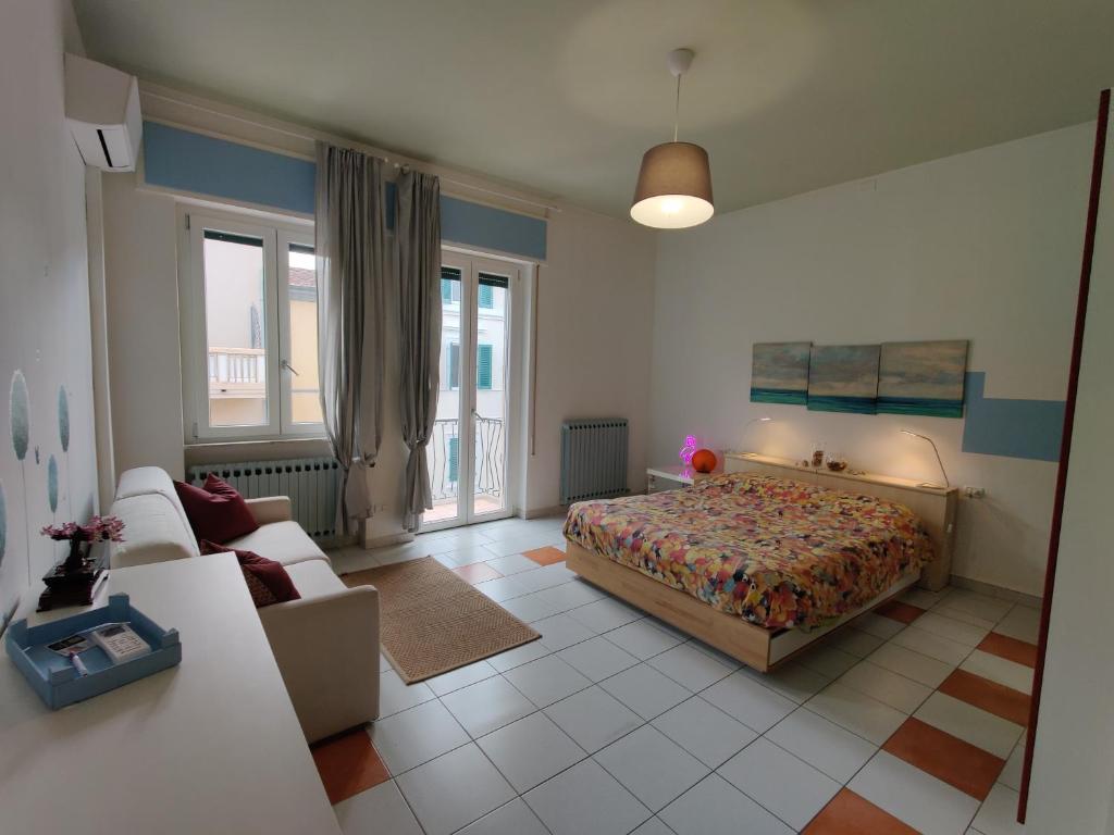 um quarto com uma cama e um sofá em Appartamento al mercato: Viareggio em Viareggio