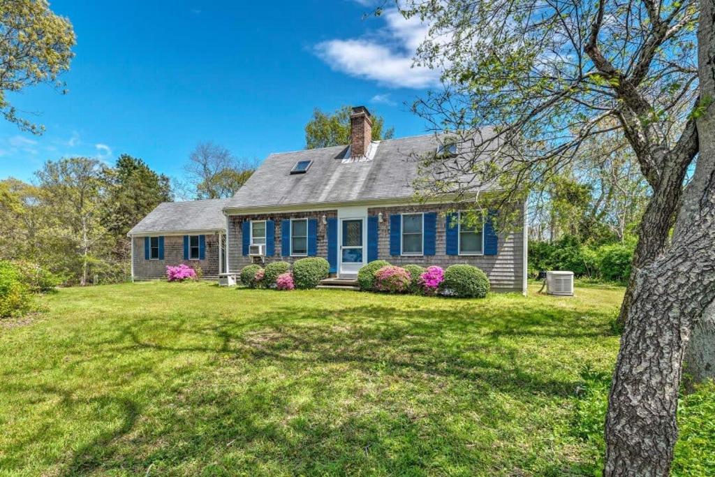 a home with a blue house with a yard at Stay On The Cape Vacation Rentals: Book Eastham Plenty Of Room For Entire Family in Eastham