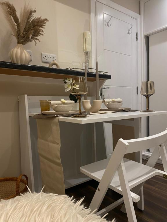 Great central Location, Stylish Studio sleeps 2 في لندن: طاولة بيضاء مع كرسي أبيض في الغرفة