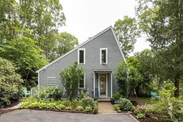 a small gray house with a driveway and trees at Stay On The Cape Vacation Rentals: Contemporary Saltbox In New Seabury in Mashpee