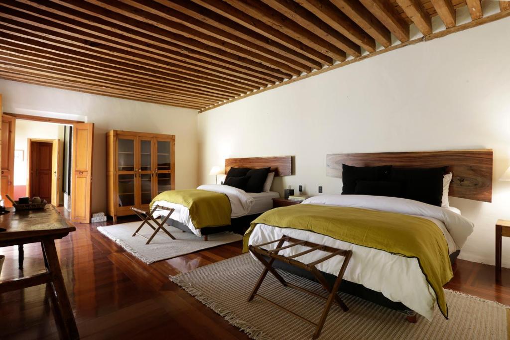 a bedroom with two beds and a wooden ceiling at Casa9 Zocalo in Mexico City