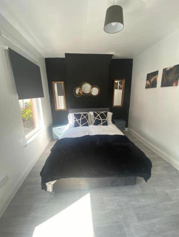 a bedroom with a large bed with a black headboard at Ideal for Contractors' Accommodation in Seacombe