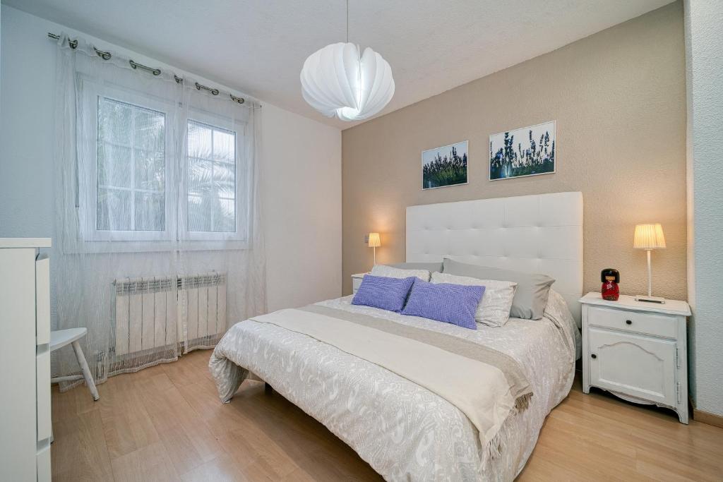 ein Schlafzimmer mit einem großen Bett mit blauen Kissen in der Unterkunft SUKI HOUSE Chalet 1 in Madrid