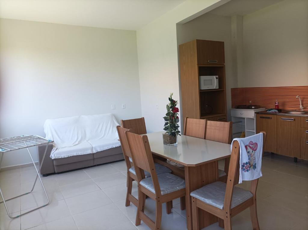 cocina y comedor con mesa y sillas en Apartamentos Beira Mar en Laranjal