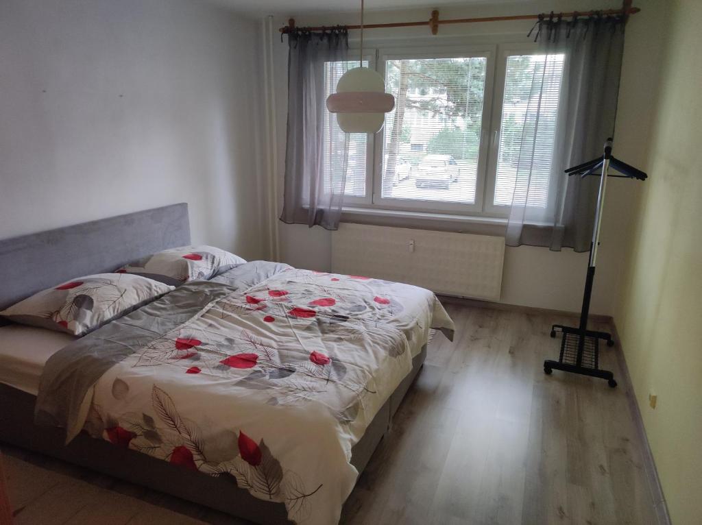 a bedroom with a bed with roses on it at Apartmán City in Zvolen