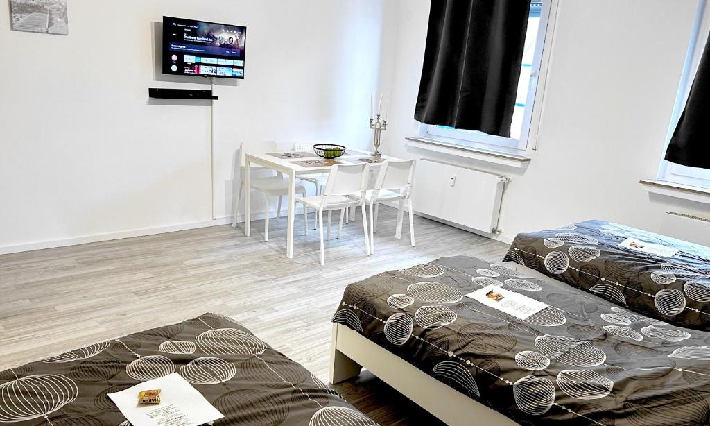 Habitación con 2 camas, mesa y TV. en # VAZ Apartments SG01-02 ,WLAN,TV, Küche, Balkon, nahe Zentrum en Solingen