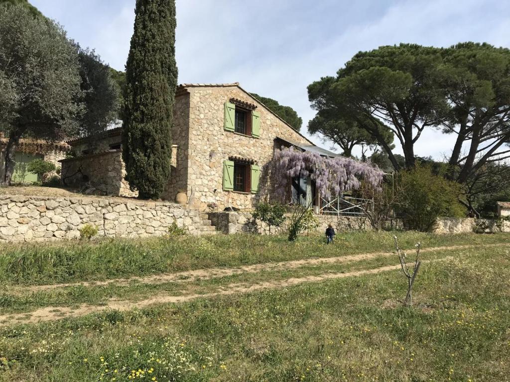une maison en pierre dans un champ avec des arbres en arrière-plan dans l'établissement Gamate, au Plan-de-la-Tour